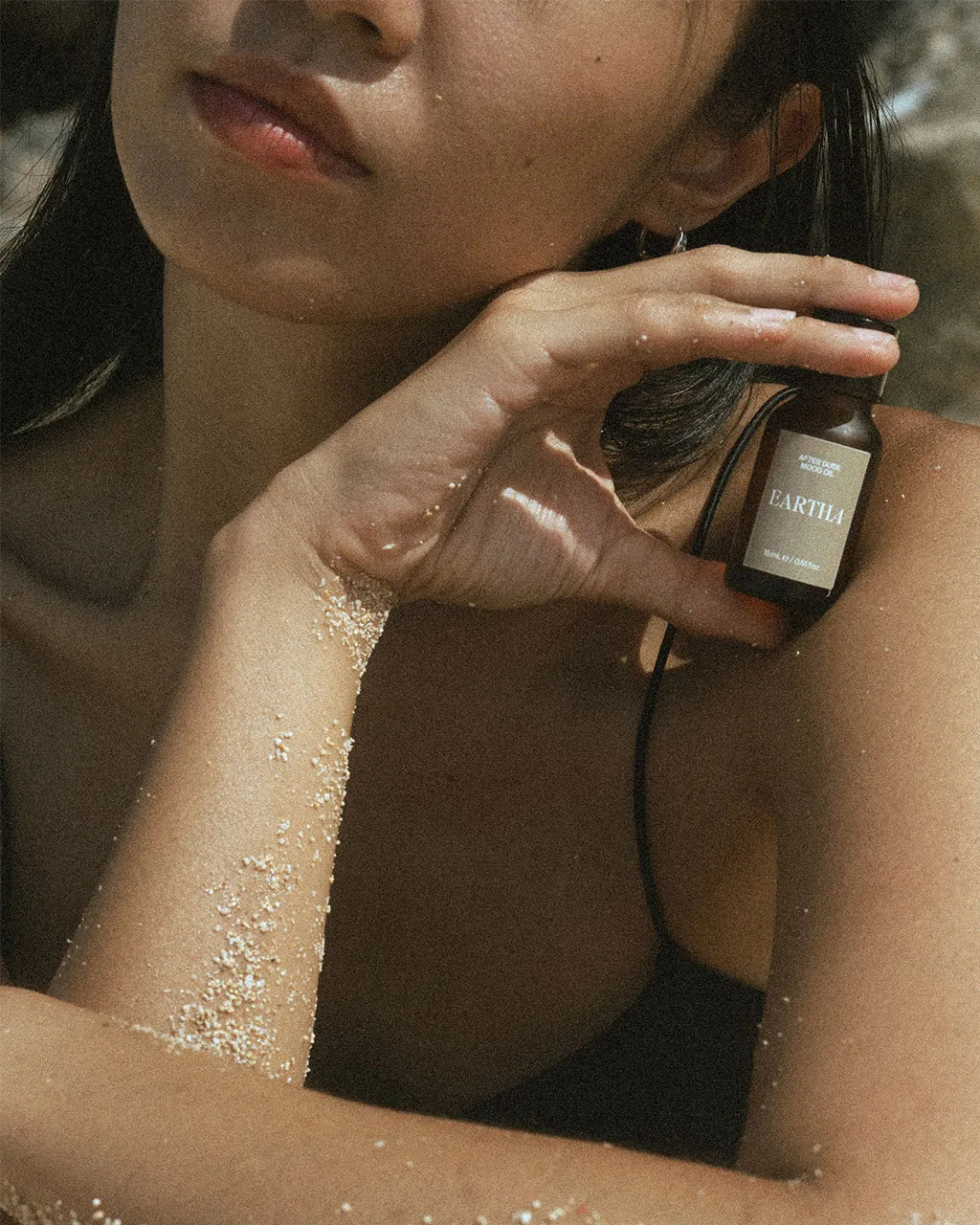 Woman holding an essential oil bottle from Eartha