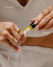 Close-up of a person holding an essential oil roll-on bottle.
