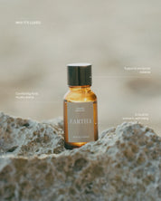 Eartha essential oil bottle on a textured surface with text about its benefits.