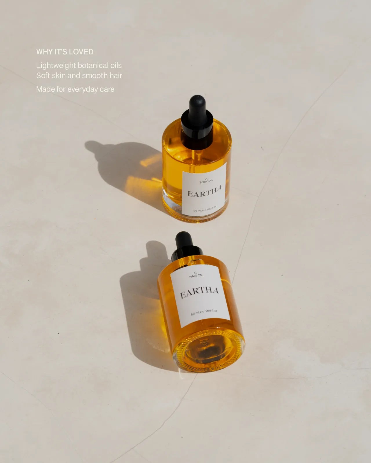 Two bottles of Eartha oils on a light background