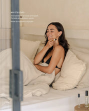 Woman using a roll-on on a bed